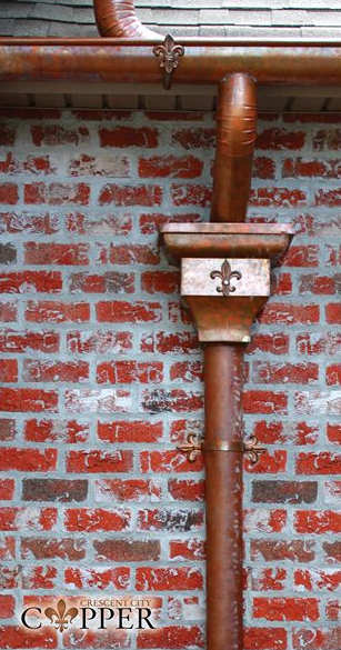 copper gutter and downspout joined by custom fleur de lis leaderhead & accents